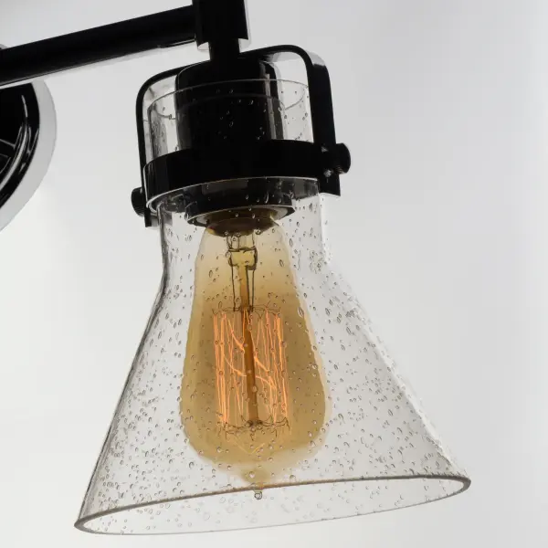 This nautical-inspired collection features Clear Seedy glass cones suspended by a yoke frame. The clear glass offers abundant lighting and compliments the styling of the fixture. Make it a more industrial look by adding filament E26 light bulbs. Collection: Seafarer Finish: Polished Chrome Glass: Seedy Width: 24.25" Height: 10.00" Weight: 5.50 lb Extension from Wall: 7.00" Wire: 8" Canopy: 4.5"x7" Number of Bulbs: 3 Maximum Wattage: 60.00 W Bulb Type: A19 Bulb Base: E26 Medium Light Source: Incandescent Light Output: 1800.00 lm Dimmable Voltage: 120.00 V Material: Steel, Glass Safety Listing: cETLus Safety Rating: Damp Manufacturer Warranty: 1 Spec Sheet Instructions Parts Diagram - alternate view