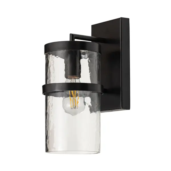 Rugged yet refined, Chamberlain pairs clean lines with a handcrafted feel. A thick glass cylinder, beautiful in its subtle imperfection, diffuses light with soft ripples and warmth. Dark Bronze strapping adds architectural structure, grounding the design while gently shielding glare. Finished in a weather-resistant powder coat, Chamberlain is made to elevate exteriors with understated elegance.