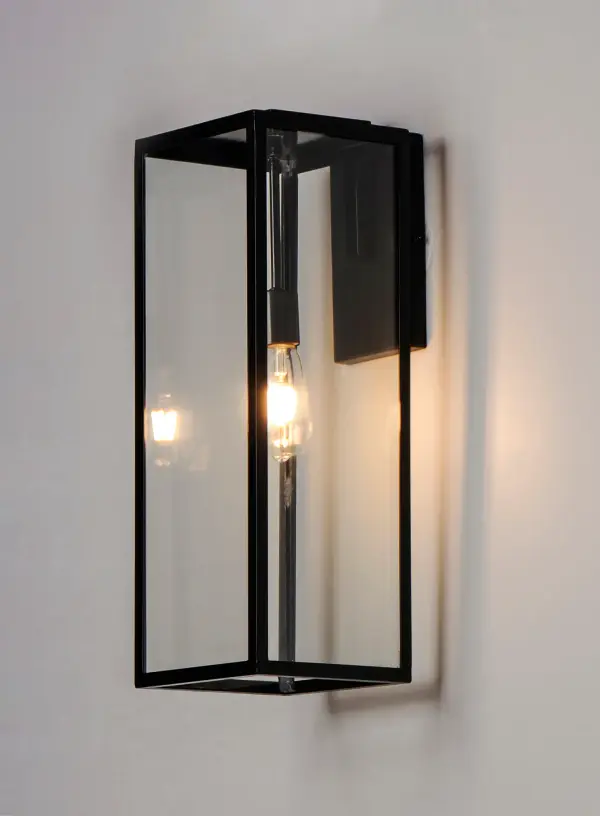 An elongated rectangular shaped design that is both minimalist and industrial. Die cast frames of Dark Bronze support Clear glass panels that provide an unobstructed view of the lantern's interior. Customize with your choice of lamps from vintage to tubular. - alternate view