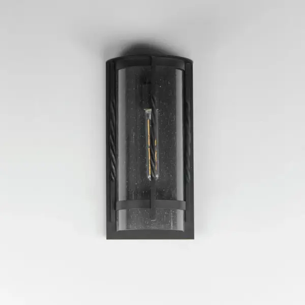 Forged iron spindles twist along the frame of a half round sconce. Transitional in design, they are finished in a Neutral Black outdoor rated powder coat and feature Clear Seeded glass. Use tubular lamps to accentuate the height of the sconces. - alternate view