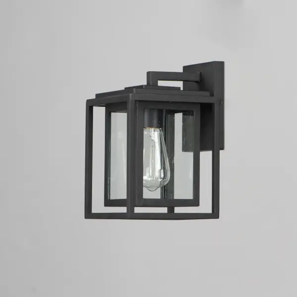A dual framed structure creates dimension on these outdoor lighting fixtures that is both contemporary and transitional. The construction consists of two frames of square tubing and squared components. The inner frame's Clear Seedy glass reduces glare from the light and appears dirt-free for longer periods. This is a comprehensive collection to brighten all areas of your outdoor space, available in various sized sconces as well as hanging and post configurations. - alternate view