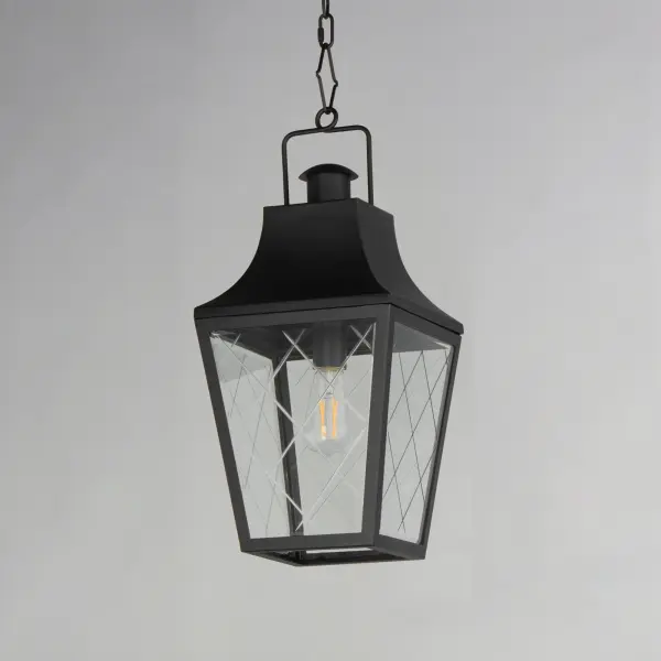 These charming cottage style lanterns feature unique cross-etched glass panels that are Clear and beveled along their edges. Additional design details such as whimsical loops above a chimney element add to the product's delightful appearance. Finished in a Matte Black outdoor rated powder coat, this collection recaptures the appeal of storybook lanterns. - alternate view