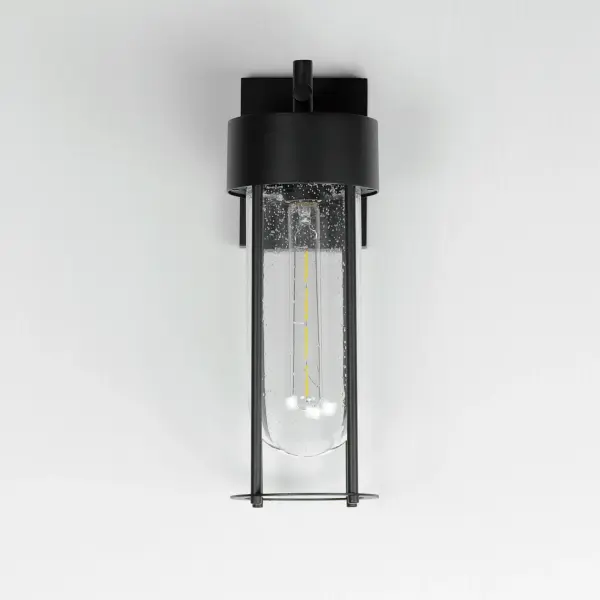 Clean and contemporary, this series of wet location rated outdoor sconces features a capsule of Clear Seeded glass encased within a cage of matte Black outdoor rated powder coat. The transitional appeal of the design pairs well in applications both modern and traditional. Complete the look with a tubular filament lamp. - alternate view