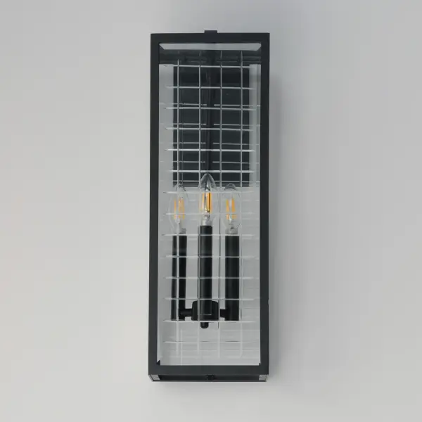 A simple square-framed lantern features deep etched squares on Clear glass, creating a captivating array of refracted light. Constructed from die-cast aluminum and finished in Matte Black, the design blends classic elements with a refreshing, modern approach, offering both sophistication and simplicity with an emphasis on minimalism. - alternate view