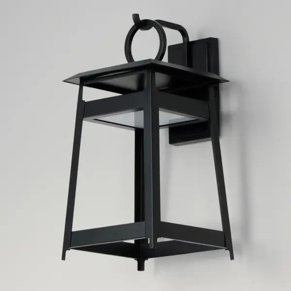 An impactful shrine of light, the modern lantern designs of the Pagoda series feature a stacked structure with slanted roof lines over an open pavilion free of glass. The LED light source is contained in the lower structure provides ample light downwards in addition to casting light upwards to create a warm glow within the frame. A large, flattened ring perches above the lanterns, which are then supported by hooks on the larger sizes. The fixtures are made more robust by eliminating the use of glass panels entirely. Finished in matte Black, these outdoor sconces are stylishly contemporary. - alternate view