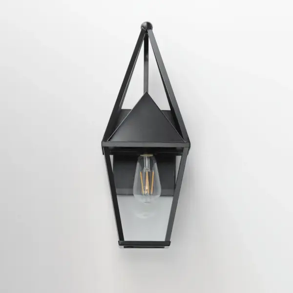 An exaggerated openwork framed steeple adds vertical qualities on a sharp-lined Matte Black lantern frame. Blending modern concepts with forms that evoke a whimsical imagery, this collection presents a transitional styling for outdoor spaces. - alternate view