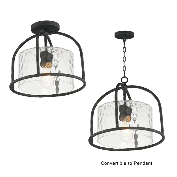 Inspired by classic European lanterns and handcrafted ironwork, the Del Mar collection brings timeless sophistication to exterior spaces. Its airy open-frame silhouette is crafted of hammered iron, elegantly arched with a graceful hook detail that nods to historic gas lamps. Inside the frame, a delicate Water glass cylinder shimmers with texture, diffusing light in a soft, atmospheric glow. Designed for lasting beauty in the elements, each piece is finished in a richly layered Blacksmith finish--a deep near-black tone highlighted by silvery brushstrokes, adding artisanal character to the silhouette. Whether flanking a grand entry or lining a garden path, Del Mar offers a refined approach to outdoor lighting with enduring presence. - alternate view