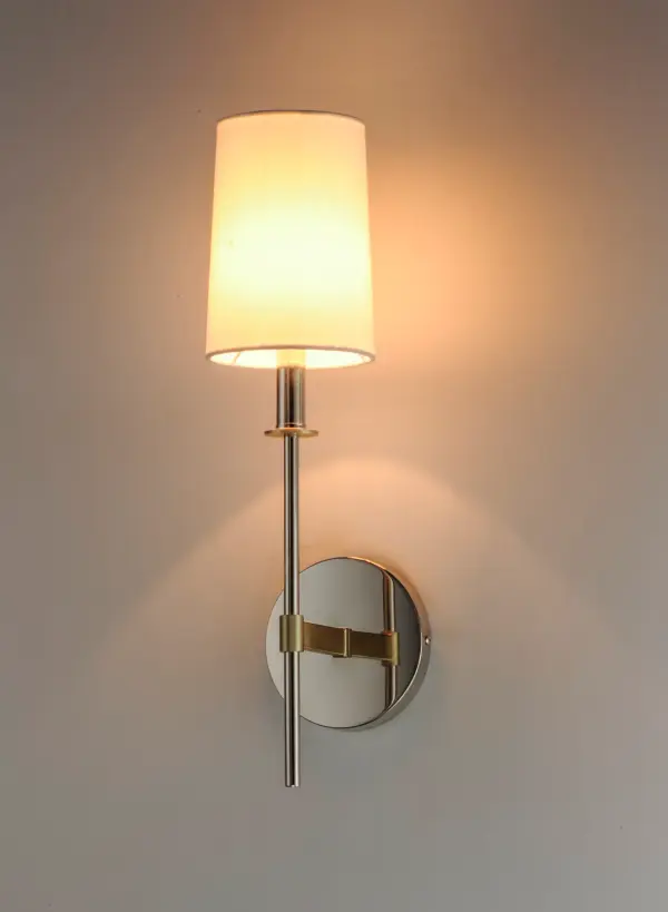 Elongated tails and candle sticks create effortless sophistication in the Uptown series. The slender candles of Polished Nickel contrast the stout supporting arms finished in a soft Satin Brass. Tall Off-White fabric shades complement the updated classic design. The simplicity of this design allows it to pair with various traditional to contemporary stylings and many color themes. - alternate view