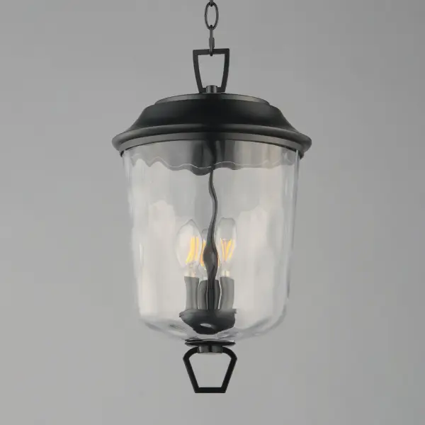 The Prescott collection of outdoor lanterns reimagines a classic design with timeless elegance. Crafted with a durable die-cast aluminum frame and finished in a sleek Matte Black, these lanterns exude a refined, understated charm. The water glass shade creates a beautiful lighting effect as it casts dazzling patterns on its surrounding surfaces. Thoughtfully updated with simple stirrup hook details, the collection effortlessly blends tradition with modern sophistication. - alternate view