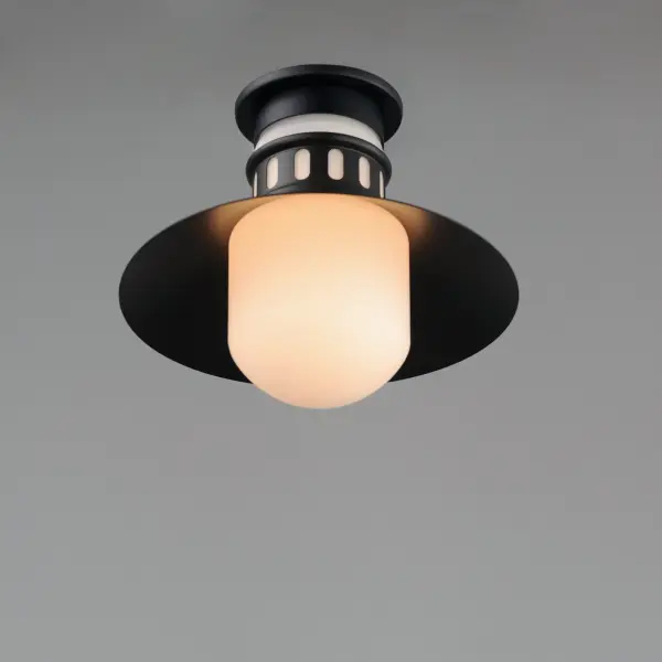 Coastally inspired, the wide brimmed aluminum spun shade on this series of outdoor rated sconces, pendants, and flush mounts features a tiered shade design. The ringed separation features a filigree of oval cut outs, whereby a single lamp illuminates the Satin White glass supporting it. The resulting light is dispersed both above and below the spun shade as well as through the patterned filigree. Both modern and classic homes can appreciate this classic design reimagined. The series is available either in Matte Black or a striking Two-Tone Black with Antique Brass. - alternate view