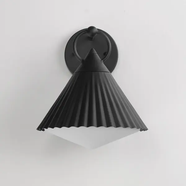 Adding charm to the outdoors, the Odette series features a scalloped pyramid shade suspended from a ring of Die Cast Aluminum. Supported within the shade is an inverse pyramid that peaks out beneath the hem of the aluminum shade marrying the two pyramid forms. Graceful and playful, these outdoor sconces add the designer touch to both indoor and outdoor locations. - alternate view