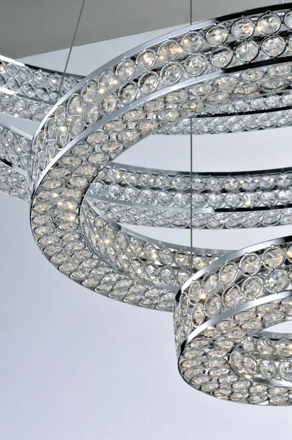 Frames of metal rings encased with Beveled Crystal Jewels, are finished in Polished Chrome. Suspended by cables as if floating In air, these rings cast rainbows of light when illuminated by the Integrated LED. - alternate view
