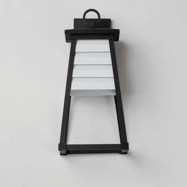 Contrasting louvered insets are set within Matte Black trapezoidal frames. The frames are made of Vivex so their finish will withstand harsher climates. The louvered panel insets are made of aluminum and feature a full cut-off design aesthetic making this design suitable for Dark Sky applications. An added benefit is the removal of glass altogether, adding a robust quality to the construction of the fixtures leading to longevity and lower maintenance. These wide plank louver panels complement the design's coastal styling adding interest in contrasting Weathered Zinc or White options, while the matte Black finish blends into the frame for a cleaner, more seamless approach. Collection: Shutters Finish: White / Black Width: 8.50" Height: 18.00" Weight: 3.41 lb Extension from Wall: 8.75" Wire: 8" Canopy: 6.75"x4.75" Number of Bulbs: 1 Maximum Wattage: 60.00 W Bulb Type: A19 Bulb Base: E26 Medium Light Source: Incandescent Voltage: 120.00 V Material: EPMM, Aluminum Safety Listing: cETLus Safety Rating: Wet Dark Sky Spec Sheet Instructions - alternate view