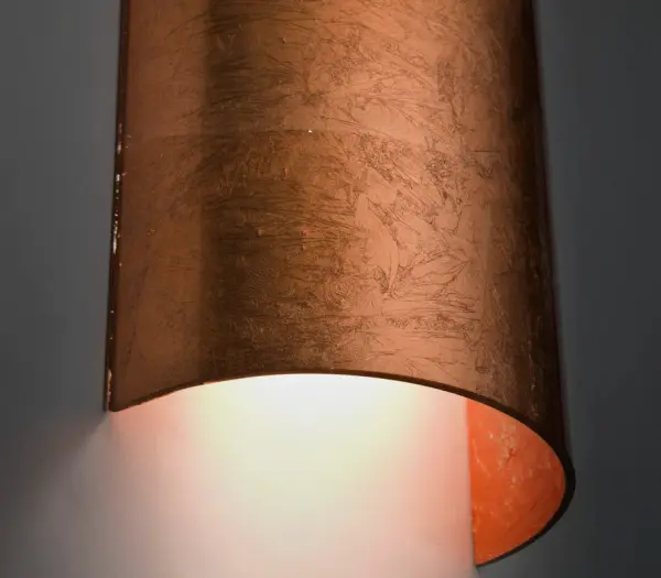 The classic colonade-shaped Torre wall sconce has minimal hardware to show off the beautiful open-ended handcrafted glass. ADA-Compliant. Our Copper Foil glass is sparkling and metallic. Distressed metal foil is applied to the inner surface of a glossy clear blown glass. This décor is full of textured and depth, however the outer surface of the glass is smooth. When lit the glass comes to life, as the distressed foil allows glimpses of light to pass through. This blown glass is handcrafted by a skilled artisan, utilizing century-old techniques passed down from generation to generation. Each piece of this décor has its own artistic nature that can be individually appreciated. - alternate view