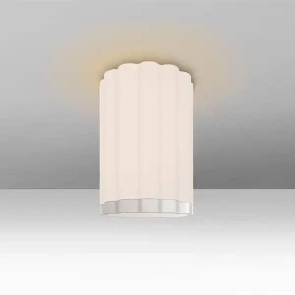 The Lando semi-flush mount features a broad fluted glass shade that creates shimmering light effects through its clear lower surface, complemented by a subtle uplight halo for ambient illumination.