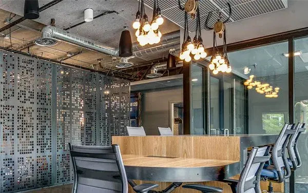 A custom-designed industrial pendant featuring a vintage pulley system for easy height adjustment. The 13-inch black powdercoat canopy with 12 ports and 10-foot cord offers versatile installation options for modern spaces.