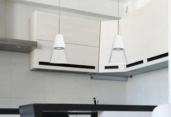 The Timo 6 combines industrial aesthetics with contemporary elegance through its clear blown glass shade and white cap design. Perfect for task lighting, this mini pendant delivers focused downlight while creating shimmer and sparkle when illuminated. - alternate view