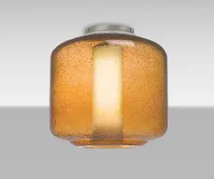 The Niles 10 features a distinctive transparent glass cylinder with random bubble patterns throughout, creating visual interest while providing functional illumination. Its compact 9.5-inch diameter makes it ideal for smaller spaces.