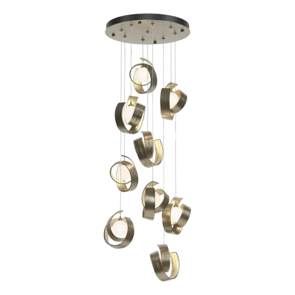 A cascade of light descends from a round canopy with the Riza 9-Light Pendant. Stunning, sculptural elements are made by hand in Vermont. You can see the hammered texture in the aluminum “swirls” that embrace each light, suspended from above. Entirely customizable, there is great adjustability in cable lengths to create a design that fits the space.