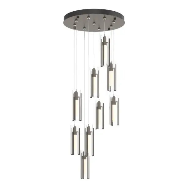 The storied Exos Collection welcomes the addition of this multi-port with nine cascading pendants clustered on a round canopy. Staggered lengths, customizable to suit the space, make this Exos 9-Light pendant and easy choice. Three tall, vertical, handcrafted steel pieces hold the glass shade within its embrace. Shades are offered in a choice of opal or clear glass.