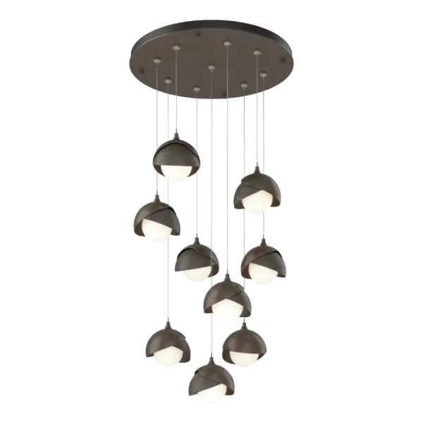 This Brooklyn 9-Light multi-port chandelier is available with a two-tone design, offering the opportunity to select contrasting finishes for Brooklyn's double shades. Shades are forged and handcrafted by artisans in Vermont, with the trademark texturing visible in the metal. Available in all standard finishes, Brooklyn 9-Light pendants can be custom-staggered on the round canopy to perfectly fill the space.