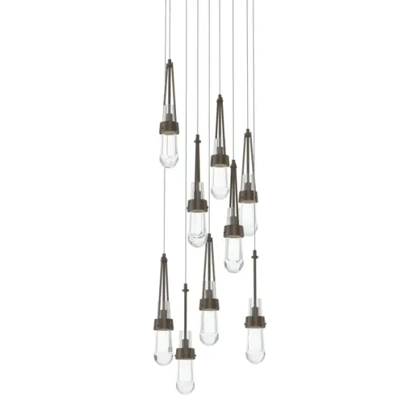 The popular Link Collection expands to include new multi-port fixtures. The Link 9-Light fixture features a round canopy from which nine pieces of clear glass are in staggered suspension. A focal piece for any space, the Link cascades downward from its canopy. Metalwork is available in all standard finishes. - alternate view