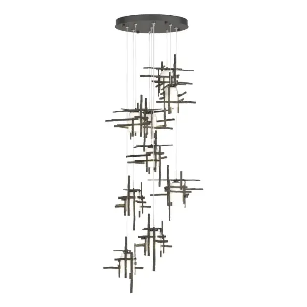The Tura's perpendicular intersecting metal pieces are crafted from annealed aluminum that are hand textured using a trip hammer and custom dies by Vermont artisans. Nine pendants with frosted glass shades, are each customizable in length on a round canopy to create the ideal staggered effect to suit its space. The Tura 9-Light multi-port chandelier is a stunning focal point, and available in all standard finishes.