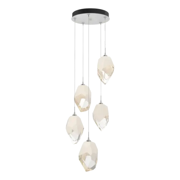 The Chrysalis 5-Light Large Crystal Pendant is a multi-port fixture that features five large, handcrafted faceted glass crystals suspended from a round canopy. A thick, clear layer of glass is encased in an outer cocoon of hand-blown, colored glass (matte black or white; all 5 are same color). The lower portion of the outer layer of glass is removed during a hand-polishing process to reveal the inner crystal clear layer below. Each crystal is lit from within. Customizable cable lengths can be shortened to create a dramatic semi-flush.