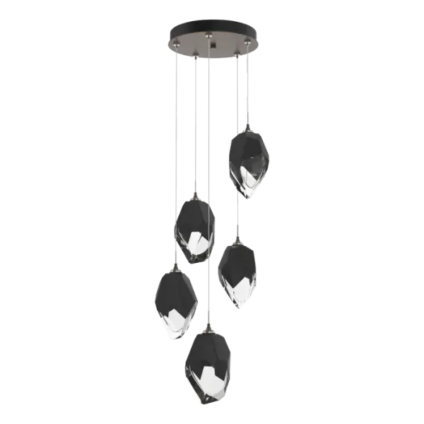 The Chrysalis 5-Light Large Crystal Pendant is a multi-port fixture that features five large, handcrafted faceted glass crystals suspended from a round canopy. A thick, clear layer of glass is encased in an outer cocoon of hand-blown, colored glass (matte black or white; all 5 are same color). The lower portion of the outer layer of glass is removed during a hand-polishing process to reveal the inner crystal clear layer below. Each crystal is lit from within. Customizable cable lengths can be shortened to create a dramatic semi-flush.