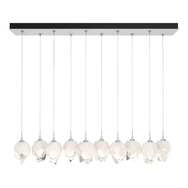 The Chrysalis 10-Light Small Crystal Pendant is a multi-port fixture that features ten small, handcrafted faceted glass crystals suspended from a rectangular canopy. A thick, clear layer of glass is encased in an outer cocoon of hand-blown, colored glass (matte black or white; all 10 are same color). Hand-polished like a gemstone, the lower portion of the outer layer of glass is removed to reveal the inner crystal clear layer below. Each crystal is lit from within.