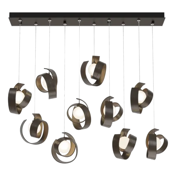 The Riza 10-Light Pendant brings a striking, sculptural design to your space. With a distinctly modern look and feel, the hammered textures are signs of the handmade nature of this fixture. Each individual sculptural, curled pendant can be easily staggered in height or aligned, allowing you to customize your installation. The rectangular canopy allows for cable adjustments with no need to cut them, giving you the opportunity to change pendant heights at will.