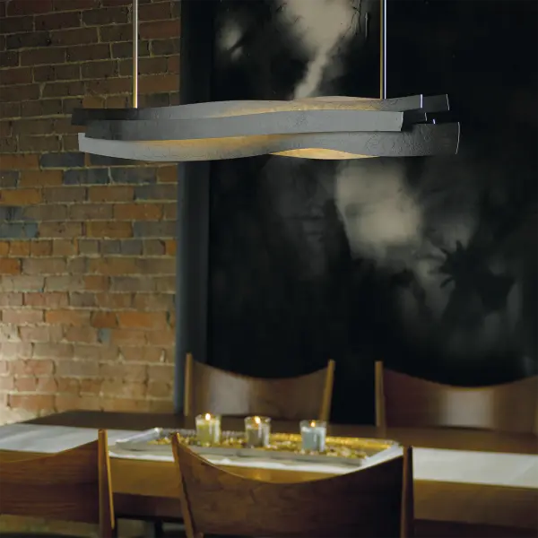 Looking at our Landscape Pendant, it's easy to imagine the bands of horizontal steel as different strata of stone and earth. LEDs glow at its core like magma simmering just below a volcano's peak. Crafted using red-hot (but not molten) metal.