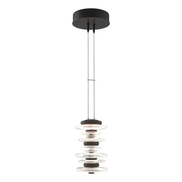 The Hubbardton Forge Cairn Pendant pays homage to the enigmatic stone sculptures, used since ancient times as landmarks. Thick hand-poured glass and cast steel “stones” are artistically stacked, and suspended by thin cables, creating a stunning illumination. Light flows over the steel and through the glass to seemingly glow from the inside. Also available as a smaller Mini Pendant.