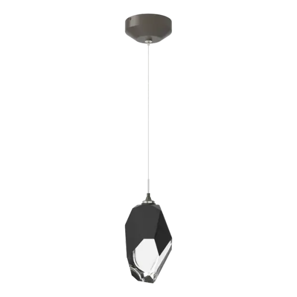 The Chrysalis 1-Light Large Crystal Pendant is a low-voltage fixture that features a large, handcrafted faceted glass crystal suspended from a small round canopy. A thick, clear layer of glass is encased in an outer cocoon of hand-blown, colored glass (matte black or white). Hand-polished like a gemstone, the lower portion of the outer layer of glass is removed to reveal the inner crystal clear layer below and is lit from within.