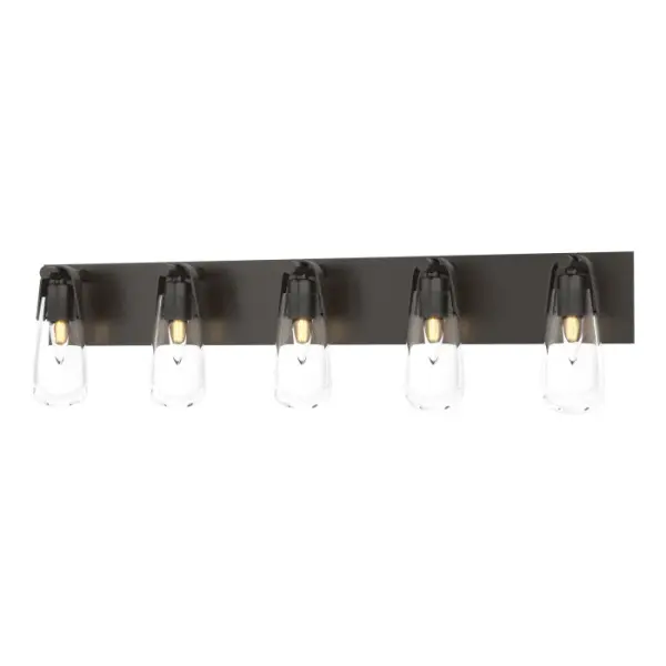This large, linear wall mounted sconce is ideally-suited to larger bath vanity environments. Delivering the functional lighting required for spa baths, the Eos 5-Light Bath Sconce is worthy of its namesake, Eos the goddess of dawn, for its dewdrop shaped glass vessel offering downward light, beautifully shown with its metal backplate and U-shaped bands.
