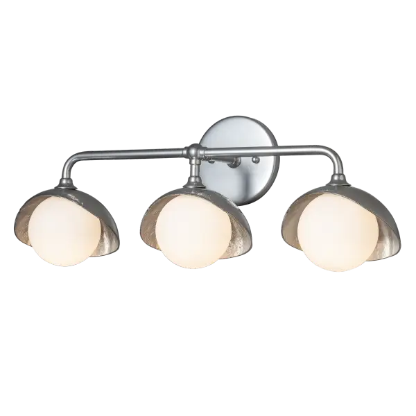 This Brooklyn Single Shade linear wall mount features three hand-forged and textured shades and glass globes on a curved arm wall sconce. Two-tone finish options available.