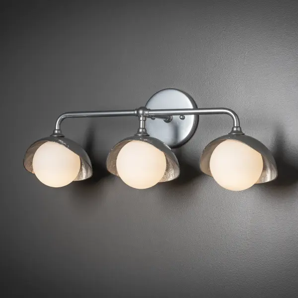 This Brooklyn Single Shade linear wall mount features three hand-forged and textured shades and glass globes on a curved arm wall sconce. Two-tone finish options available. - alternate view