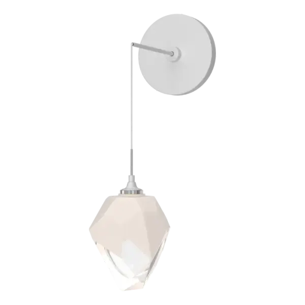 The Chrysalis Small Low Voltage Sconce features a small, handcrafted faceted glass crystal. You can custom-set the drop height, creating unique opportunities for vanity, beside and other applications. The Chrysalis’ trademark thick, clear layer of glass is encased in an outer layer of hand-blown, colored glass (matte black or white). Hand-polished like a gemstone, the lower portion of the outer layer of glass is removed to reveal the inner crystal clear layer below that is lit from within.