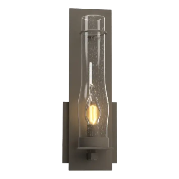 There's a sense of strength and permanence when you look at a classic work of hand-worked iron. The clear, seeded hurricane glass gives this vertical sconce a sense of old-world charm.
