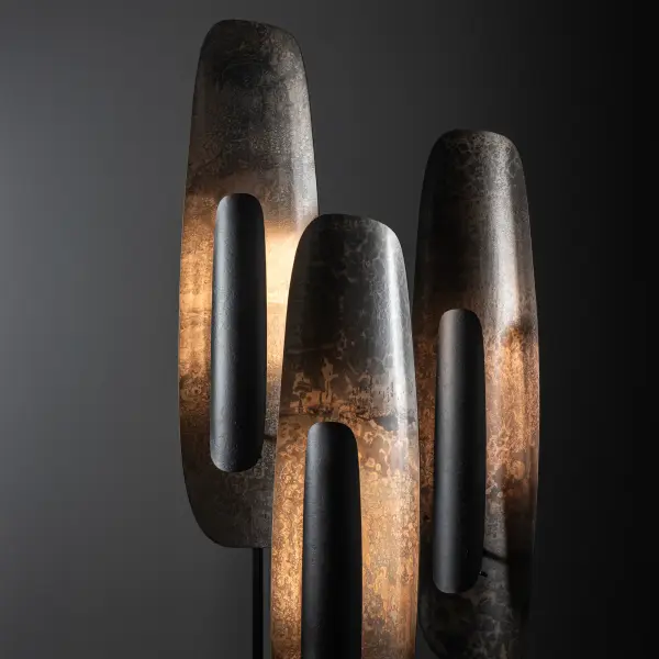 The Shield Short Floor Lamp stands at over 4’ tall. Whether placed on the floor, the outer hearth of a fireplace or elevated on a console, this shorter Shield isn’t lacking in presence. Two large plates of heavily forged steel are gently curved to great effect. The large back plate is curved vertically creating a concave surface. This heavily forged surface is illuminated by LED shielded by the smaller, narrower, sleek outer plate that is vertically curved and standing off the larger steel plate hiding the LED element from view. A dimmer rod, located at the back of the lamp allows for easy adjustment of the light to create just the right mood. The dimmer rod, stem and base are available in any of our standard finishes. The Shield plates are available in your choice of Accent Finishes, including the new Clear finish. Shield Lamps are available in 3 sizes (Short, Medium, and Tall). Try them in a cluster! - alternate view
