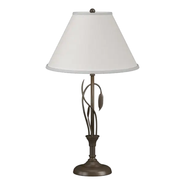 Our table lamp is an example of "sylvan steel." Stems of hand-forged iron sprout from the lamp post, with one gently curved stem culminating in a finely-crafted leaf. Shaped by artisans at our forge here in Vermont, each piece is unique. - alternate view