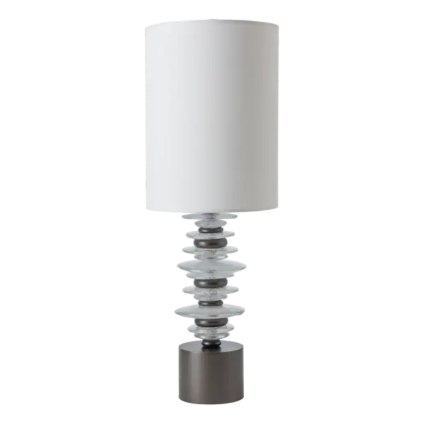 The Cairn Table Lamp is sleek and stylish. At 32" in height, it is tall enough to give substantial light to its surrounding surface. The Cairn features a dozen hand-poured glass "stones" intersperced with smaller steel "stone" elements. A tall cylindrical shade elevates the lamp's sophisticated allure. - alternate view