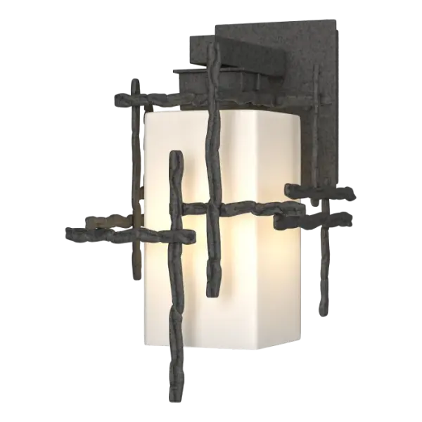 The Tura Small Outdoor Sconce is a smaller exterior wall-mounted fixture suited perfectly to outdoor settings needing multiple wall lights, including outdoor kitchen and lounge areas, patios, and other home exteriors. Made by hand in Vermont, Tura "twigs" are crafted of hammered, annealed aluminum and encase an opal shade held by a short aluminum arm and plate from above. Available in our Coastal Outdoor Finish options.