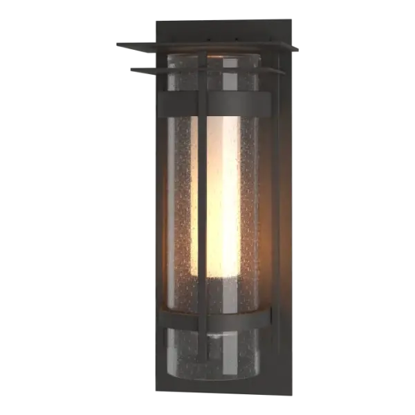 Our Torch Sconces with Top Plate are offered with a substantial and stunning seeded outer glass combined with a frosted inner glass. In addition to the two hallmark circular metal bands and its perpendicular metal accent, this version offers a square metal accent and top plate. Available in all of our robust Coastal Outdoor Finishes. The Banded Outdoor Sconce with Top Plate is also available in a large version.