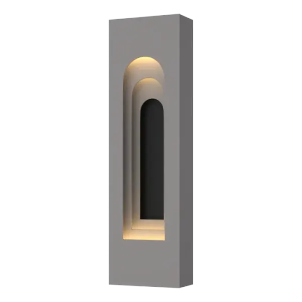 Inspired by a visit to the Grundtvigs Church in Copenhagen, the Procession Arch Small Outdoor Sconce takes the idea of spatial progression, utilizing forced perspective to achieve its timeless aesthetic. The original Gothic arch was transformed into a Roman arch in this aluminum wall-mounted sconce. Part of ART + ALCHEMY by Hubbardton Forge. Designed for the outdoors, yet beautiful enough for the indoors, as well.