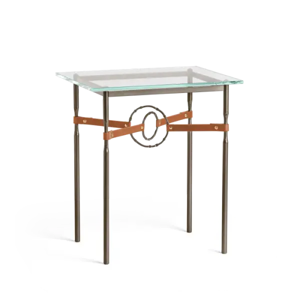 The Equus Side Table is the perfect accent to a sophisticated setting. A side table with a touch of glam', the Equus is perfect for living and lounge areas, studies and other spaces. With its artisanal leather strapping connected by hand-forged and hammered steel rings, and a tempered glass top, the Equus adds both function and refinement to any setting. Available in all standard finishes.