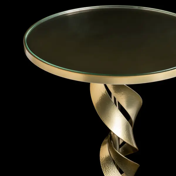Make a bold statement in your living space with the Folio Accent Table. Hand-forged steel ribbons seem to dance around the pedestal. The Folio's craftsmanship celebrates the beauty of organic movement. With its sleek silhouette and fine details, it's a timeless accent for any room. Its clear glass top puts the Folio on full display.