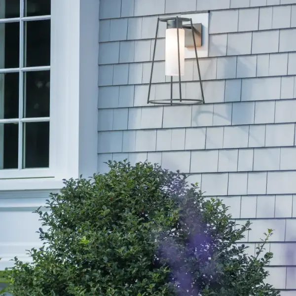The Loft Outdoor Sconce is a clean modern version of classic conical lantern design. The open geometric frame is lit from within by your choice of seeded or opal glass cylinders. Also available in standard and large versions.