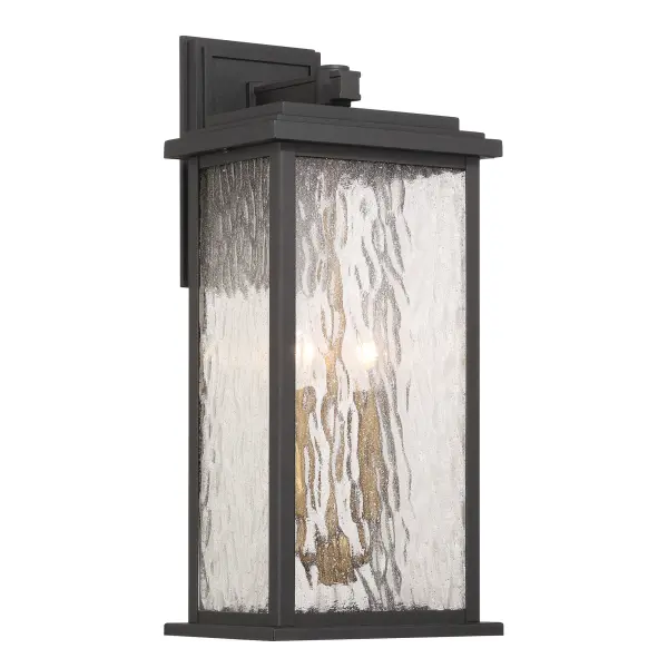 Brass with Rain Glassware The “Estate” Collection outdoor wall sconce radiates classic allure, with its black metal frame offering a striking contrast to the mesmerizing water glass panels. Encased within, vintage brass candle covers and intricate metalwork glow warmly, evoking a sense of nostalgic charm. Perfect for enhancing any outdoor space, this sconce blends classic sophistication with modern durability. - alternate view