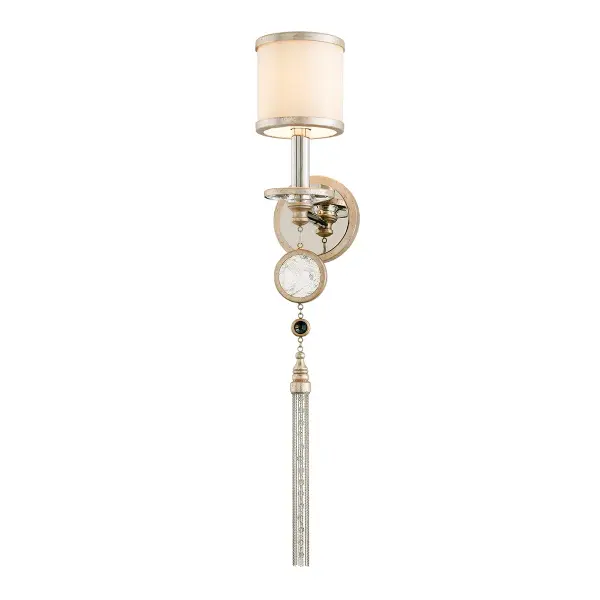 The Bliss Wall Sconce delivers traditional opulence with its hand-worked iron construction, warm silver leaf finish, and decorative beaded tassel. The frosted glass shade provides soft, flattering illumination perfect for intimate spaces.